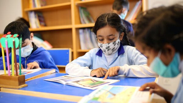 Photo d'enfants avec masques dans une classe