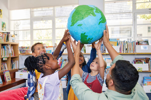 Photo montrant des enfants et un adulte disposés en cercle et portant un globe terrestre